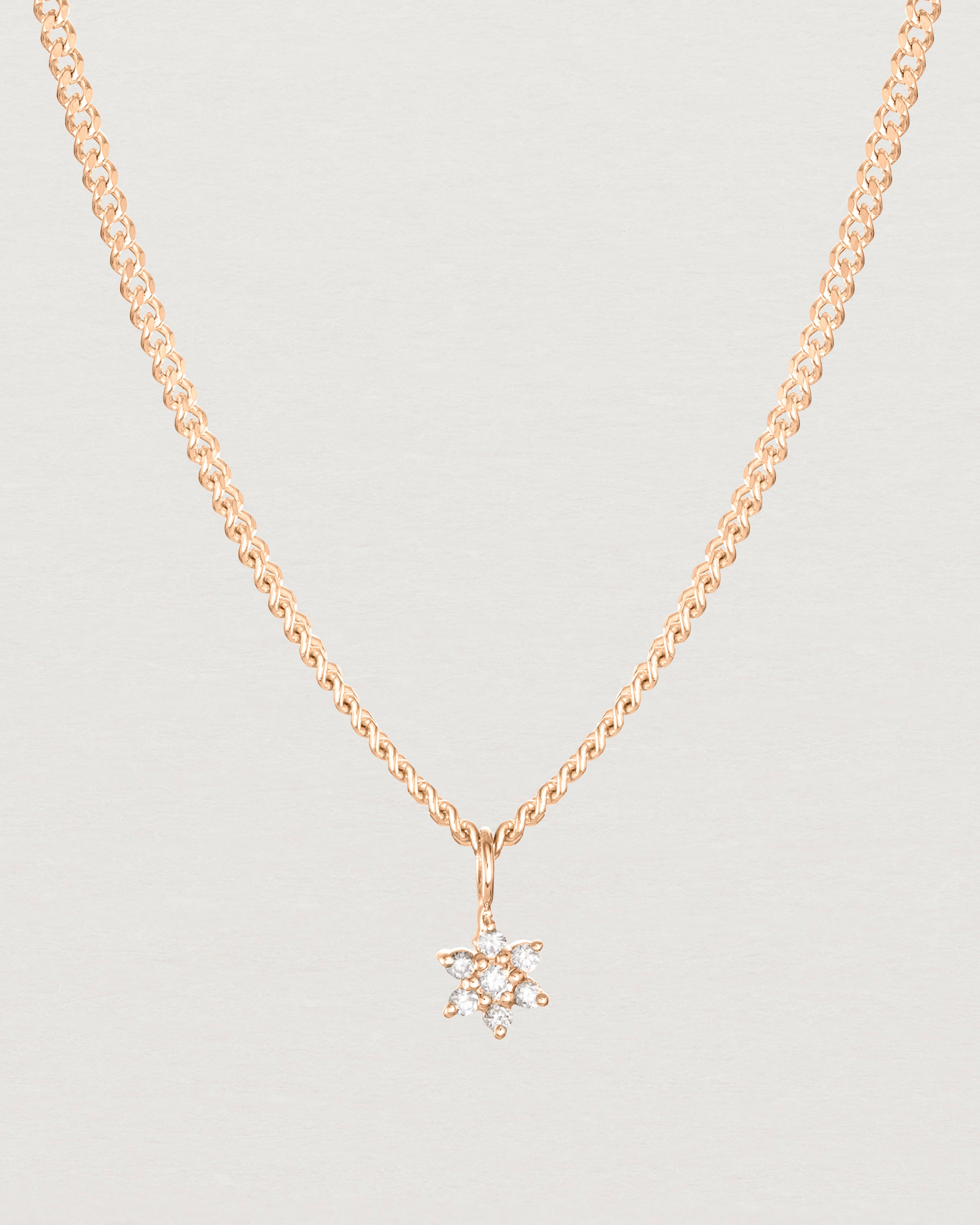 Close up image of the petits starburst diamond necklace in rose gold.