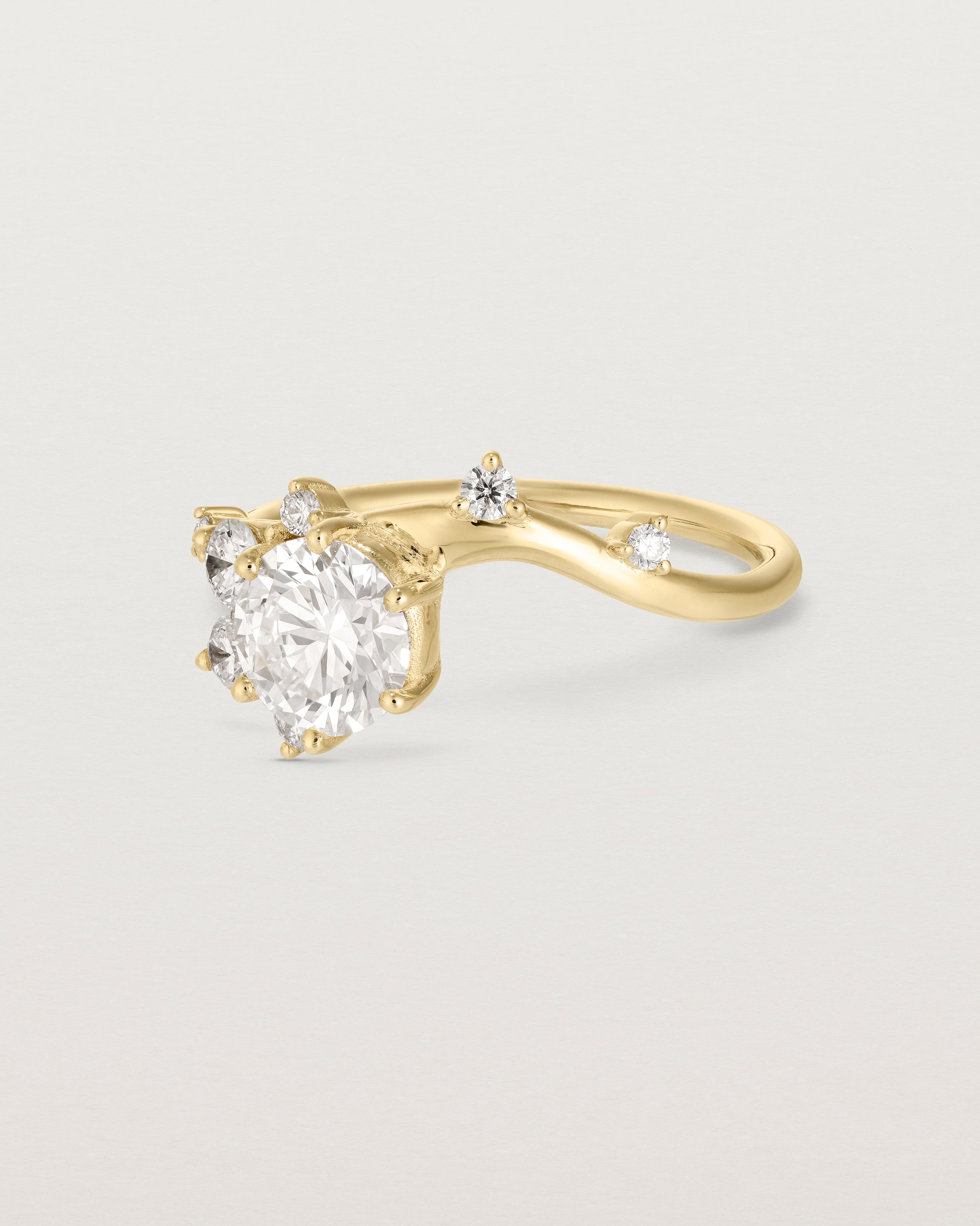 side facing deep etched image of a yellow gold  engagement ring with a cluster of laboratory grow diamonds