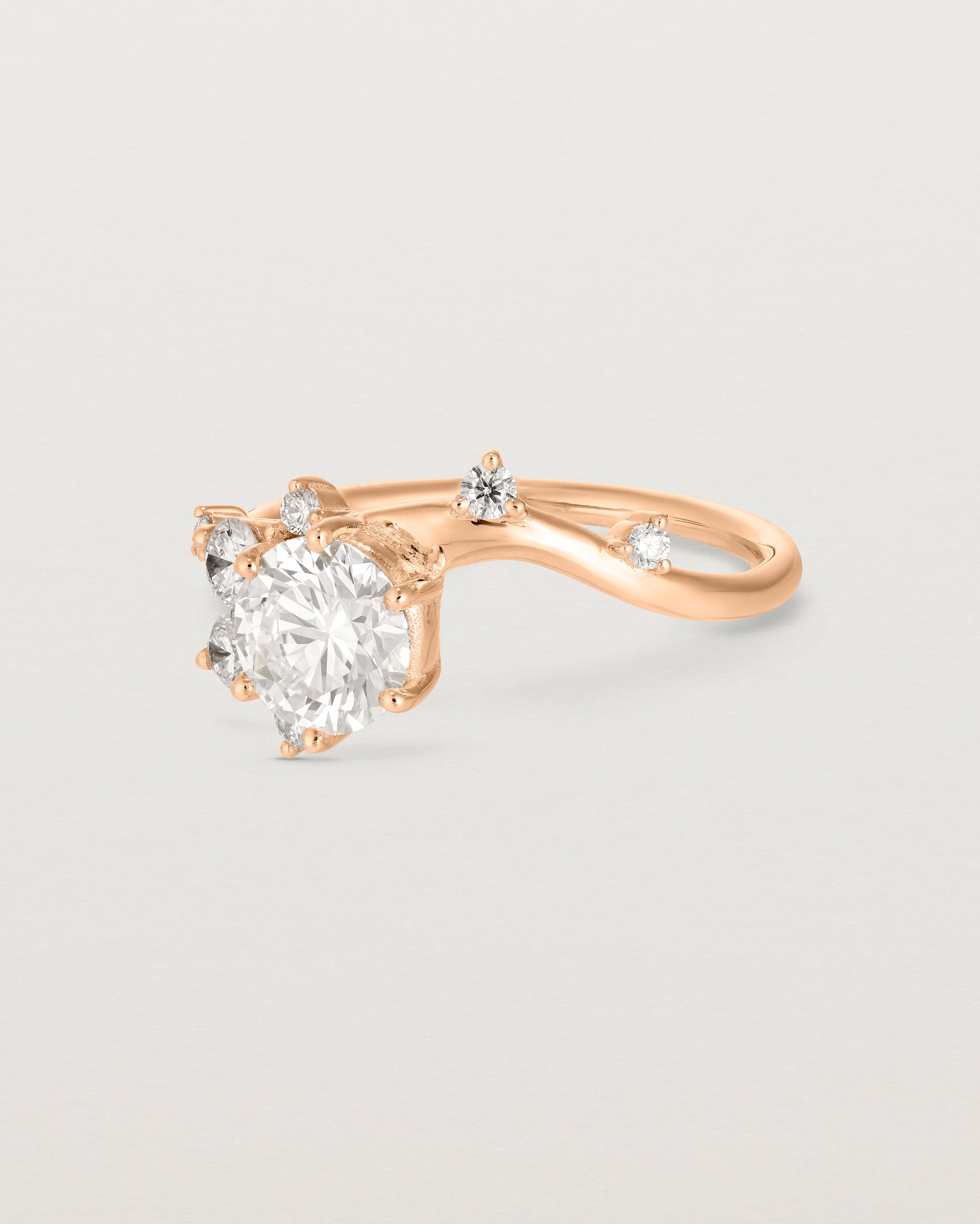 side facing deep etched image of a rose gold  engagement ring with a cluster of laboratory grow diamonds