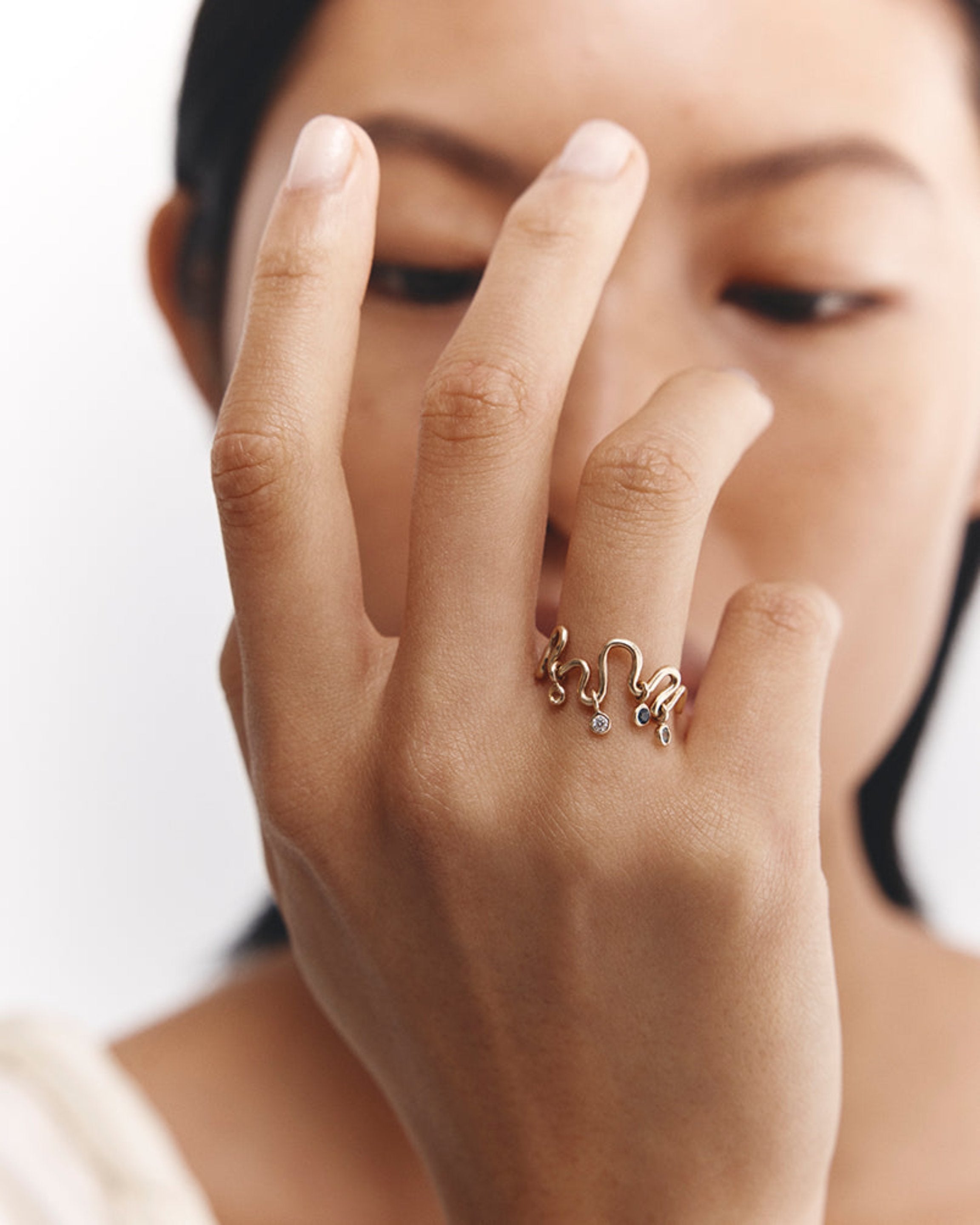 Model wears Rumi charm ring with four birthstones.