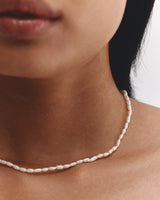 Image of a woman wearing a pearl necklace with a shorter length