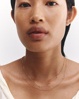 Model wears our Tellue necklace and Lai Chain necklace in yellow gold.