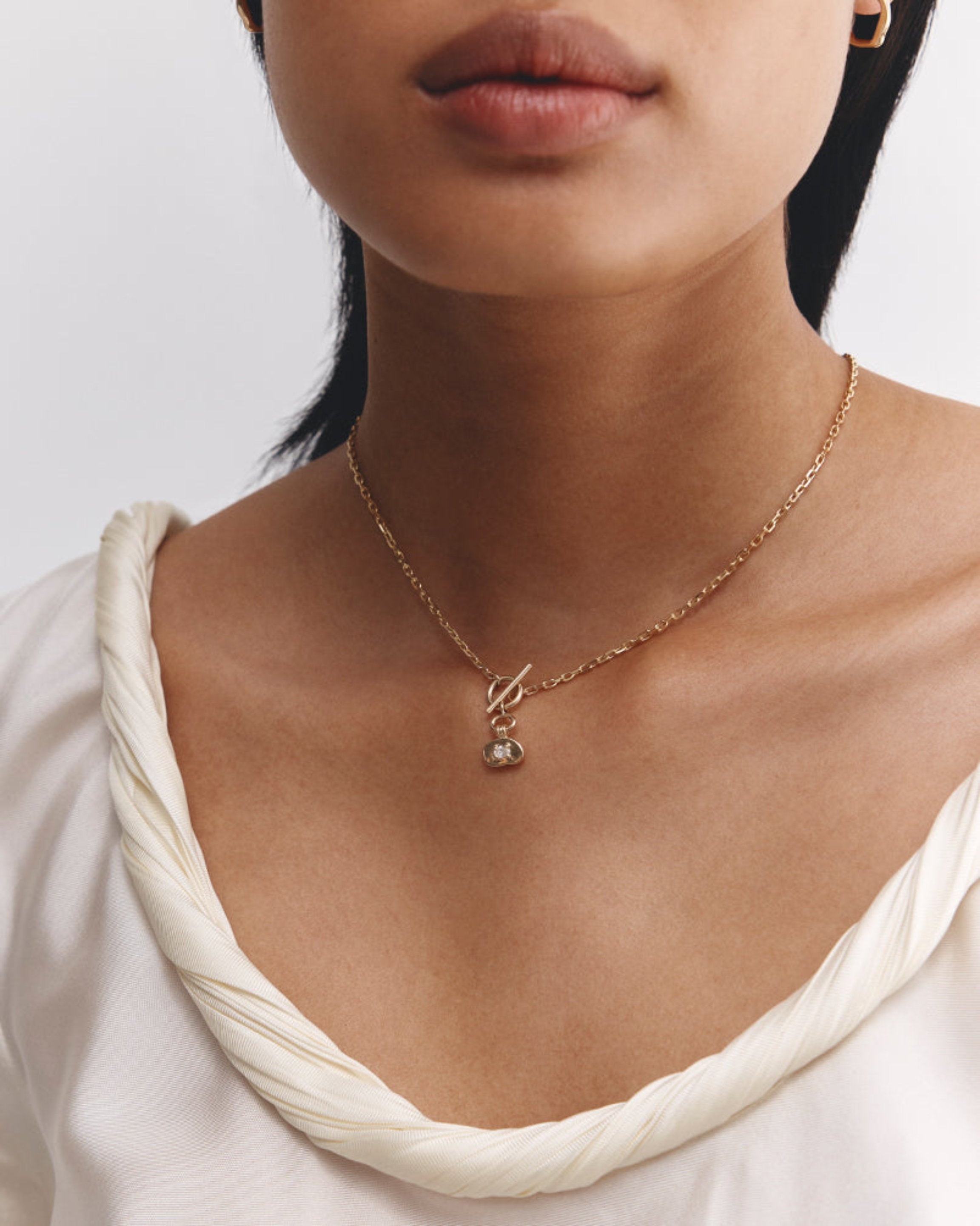 A woman wearing the Terra Necklace | Diamond in yellow gold.