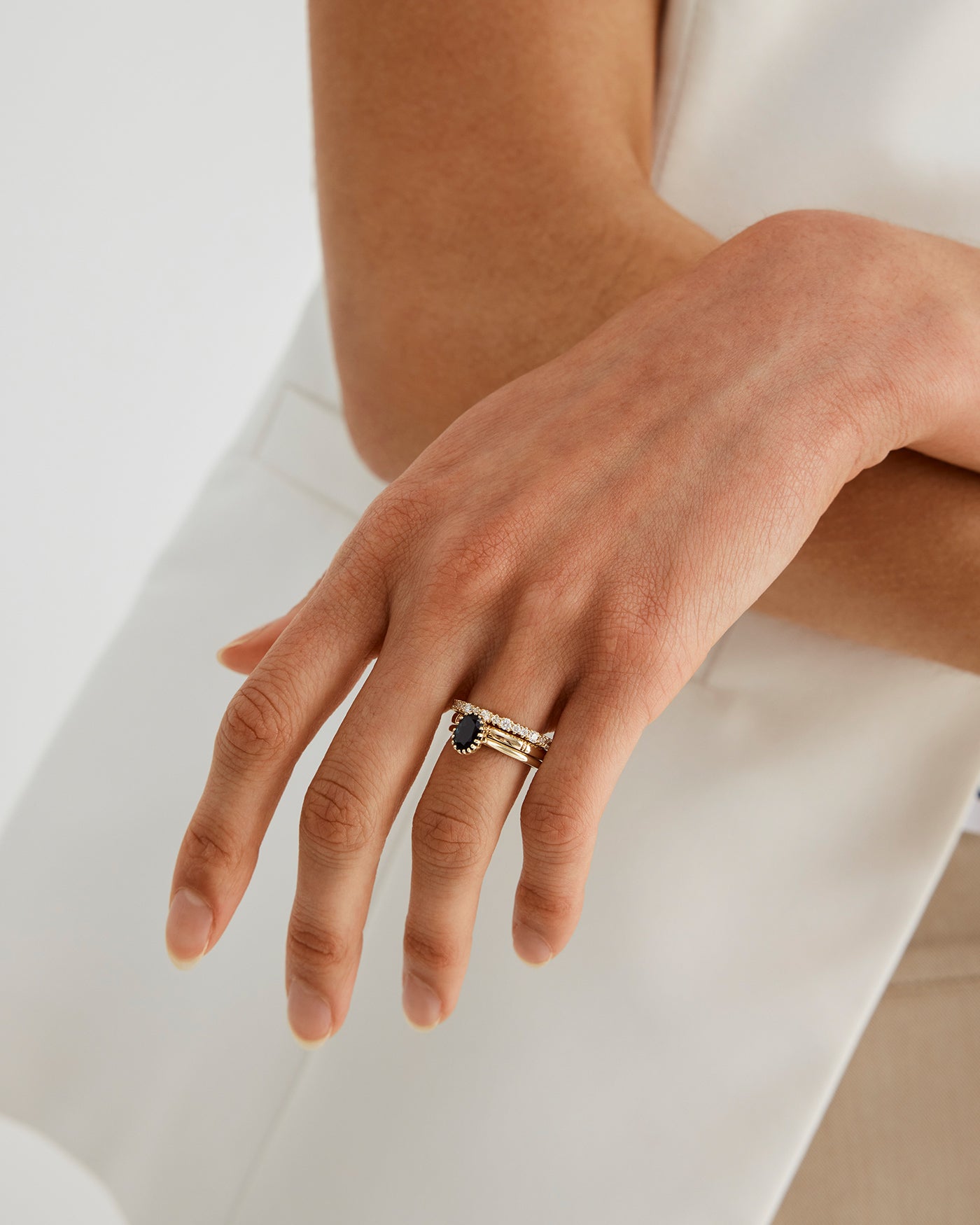 A woman wearing the Thea Oval Solitaire in Australian Sapphire