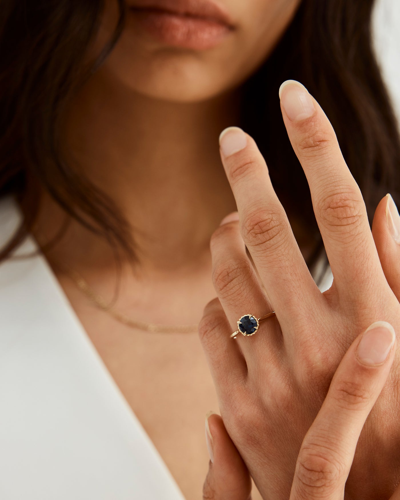 A woman wearing the Thea Round Solitaire ring in Australian Sapphire