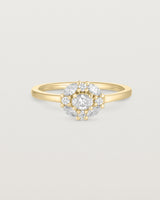 deep etched image of a yellow gold engagement ring with an oval white diamond and a halo of eight diamonds. 