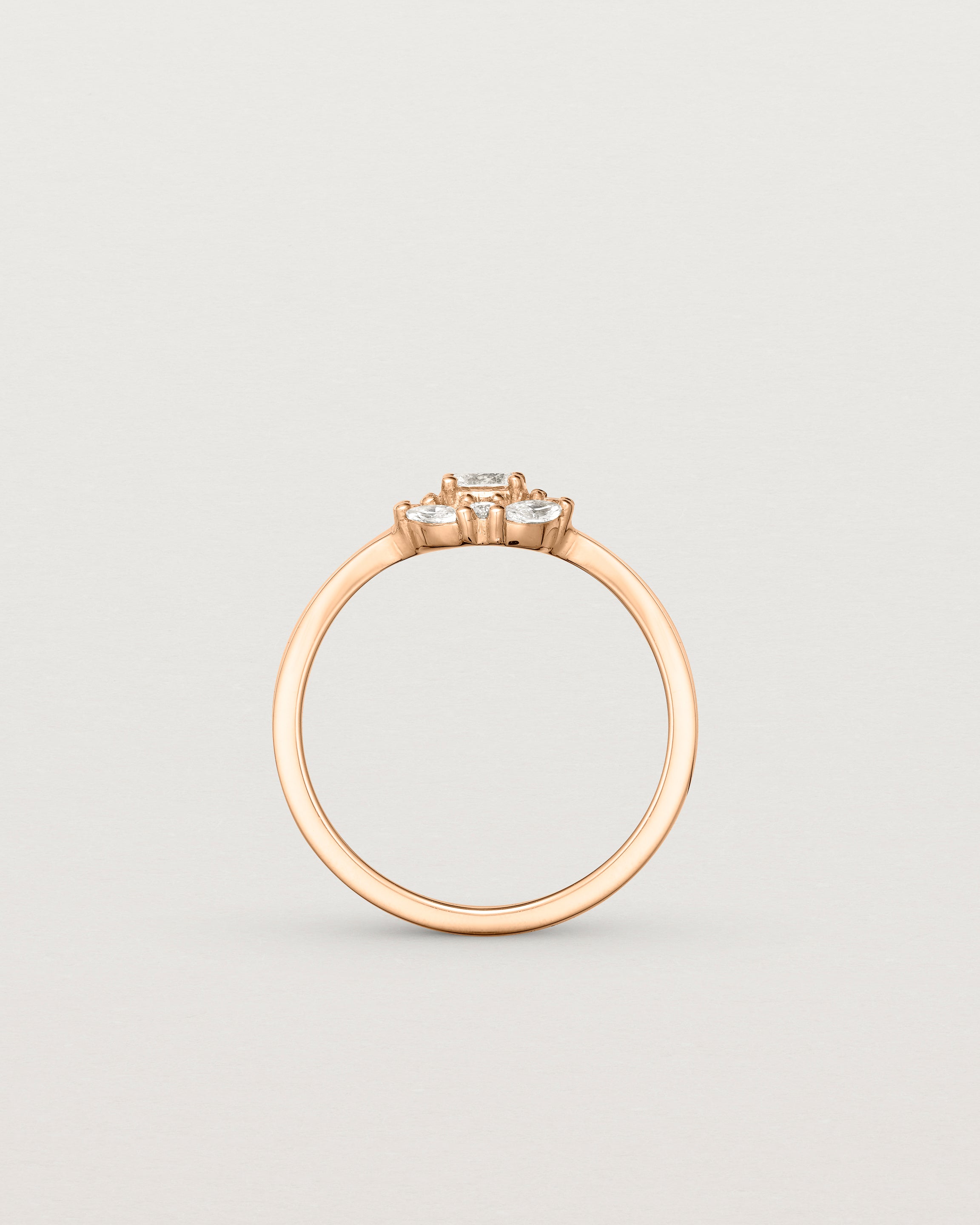 Standing deep etched image of a rose gold engagement ring with an oval white diamond and a halo of eight diamonds.