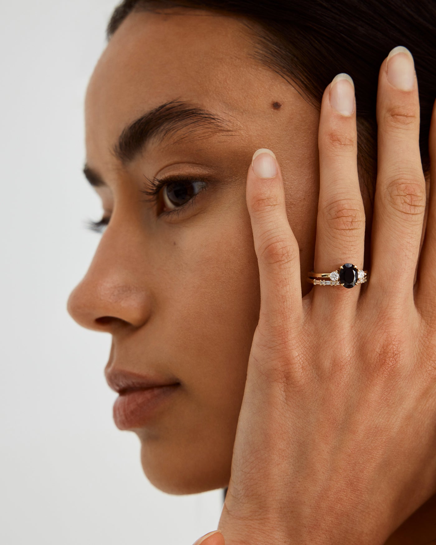 A woman wearing the Una Oval Trio Ring in Black Spinel & Diamonds