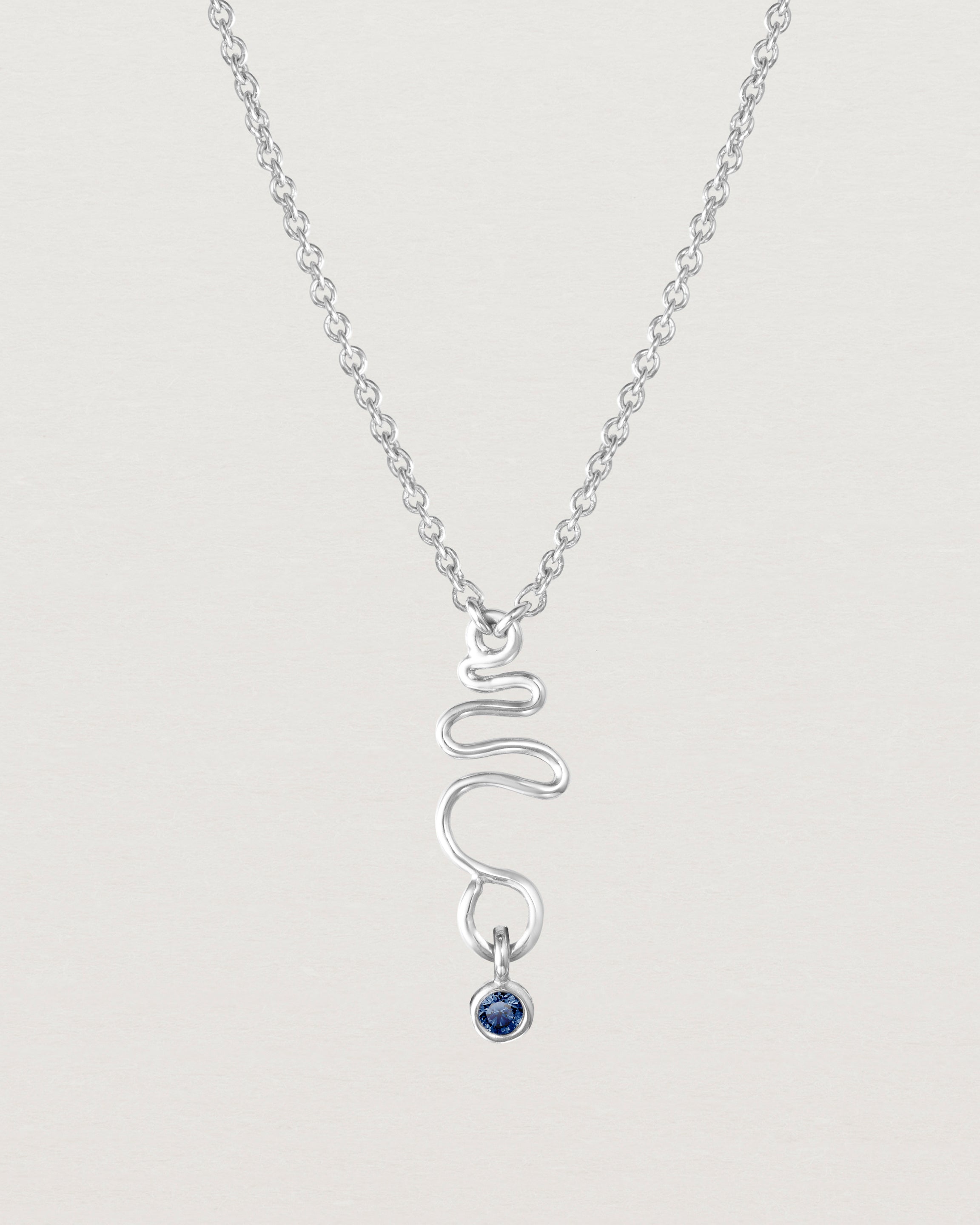 Front on deep etched image of a white gold necklace with birthstone charms.