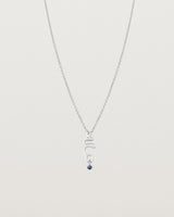 Front on deep etched image of a white gold necklace with birthstone charms.