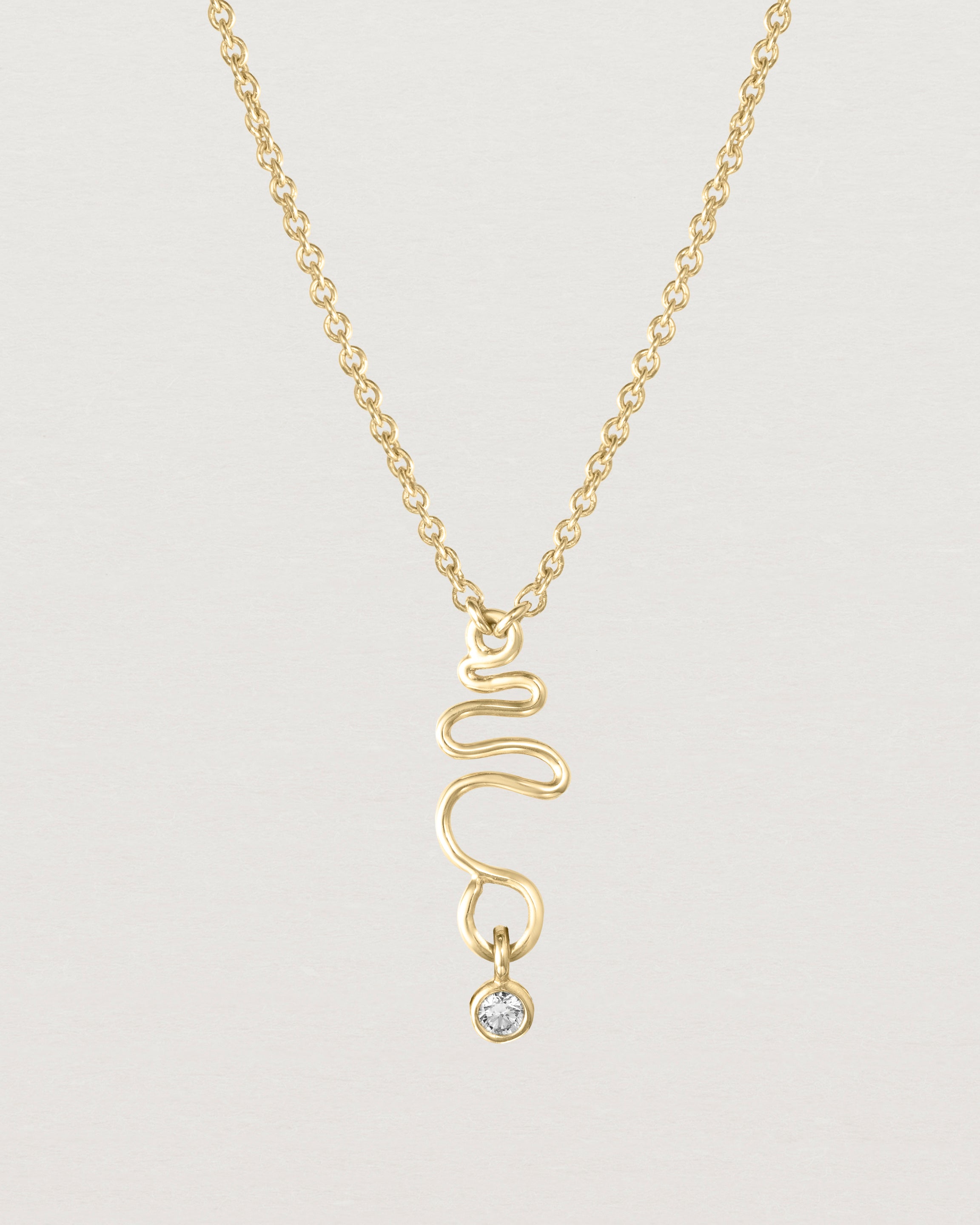 Front on deep etched image of a yellow gold necklace with birthstone charms.