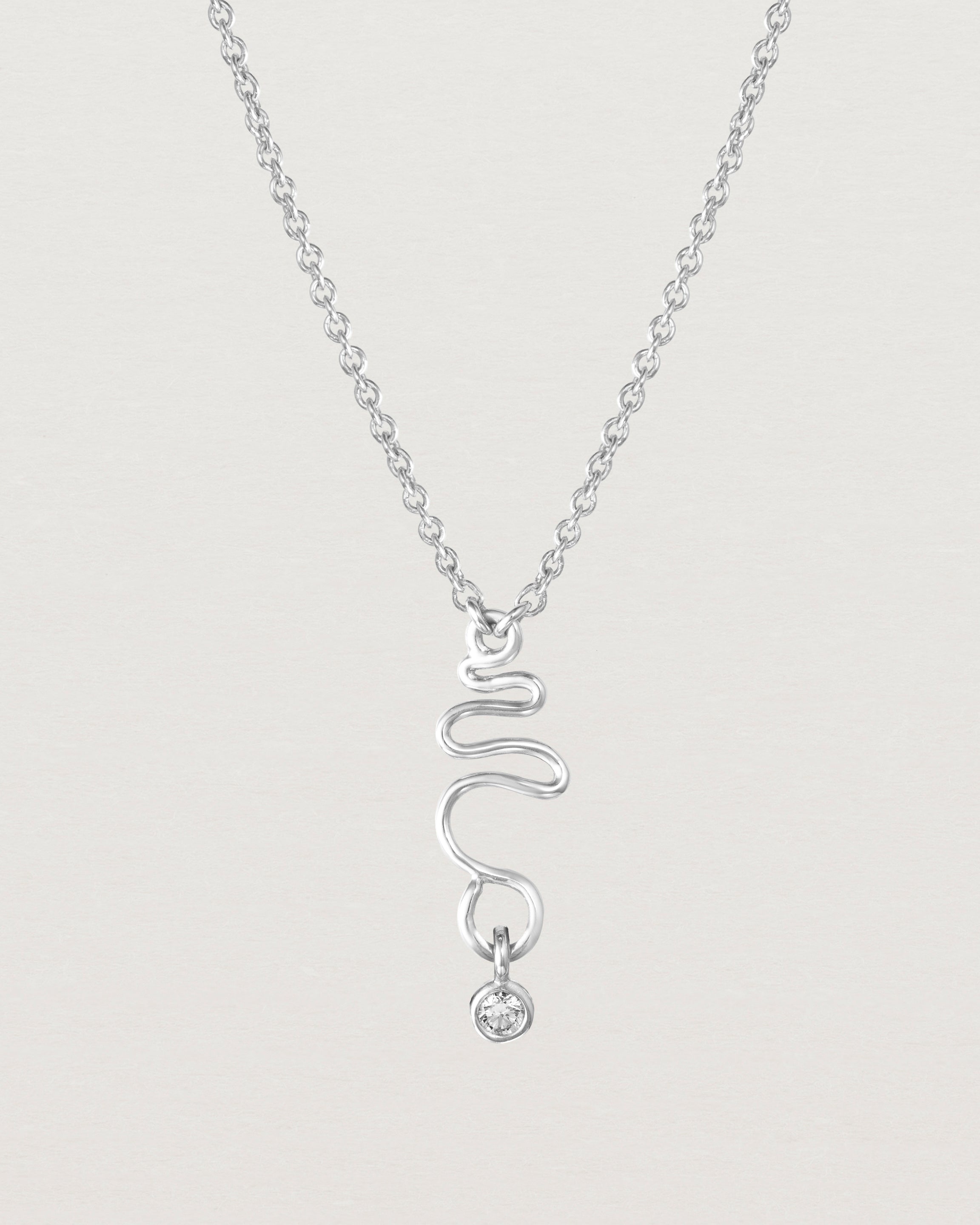 Front on deep etched image of a white gold necklace with birthstone charms.