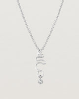 Front on deep etched image of a white gold necklace with birthstone charms.