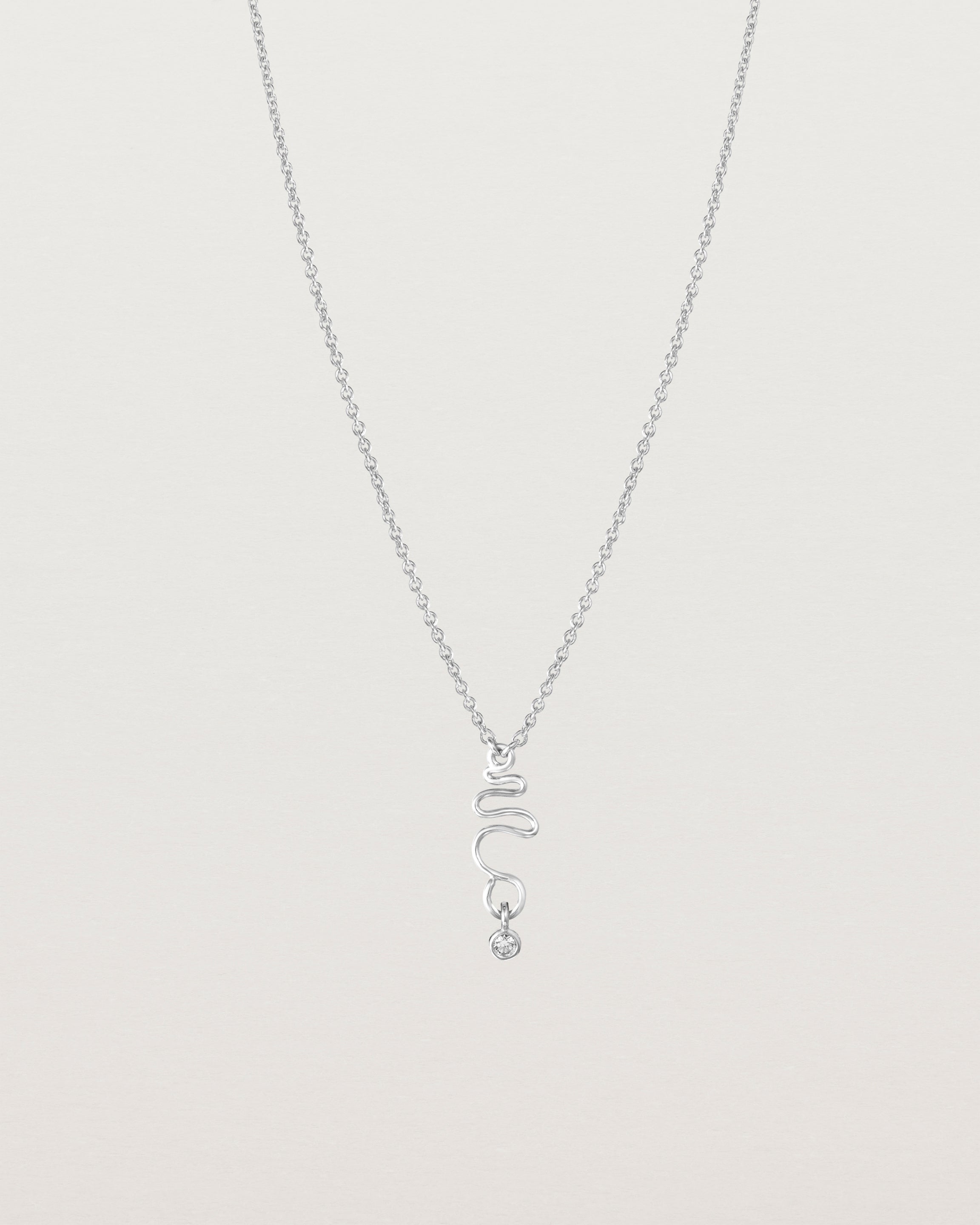 Front on deep etched image of a white gold necklace with birthstone charms.