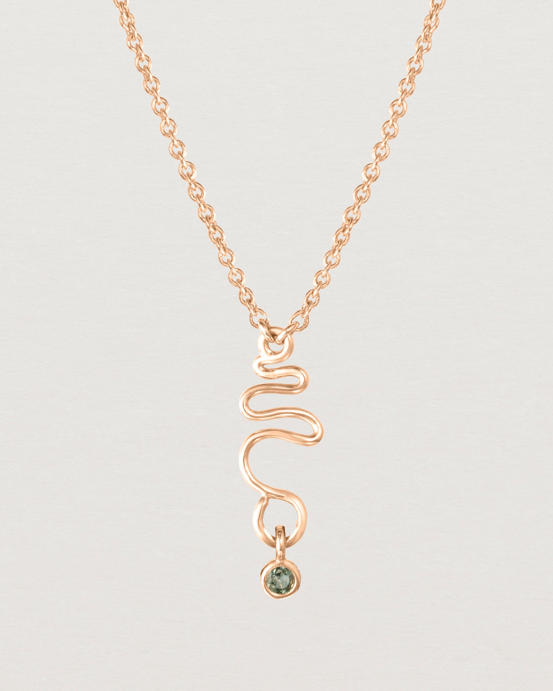 Front on deep etched image of a rose gold necklace with birthstone charms.