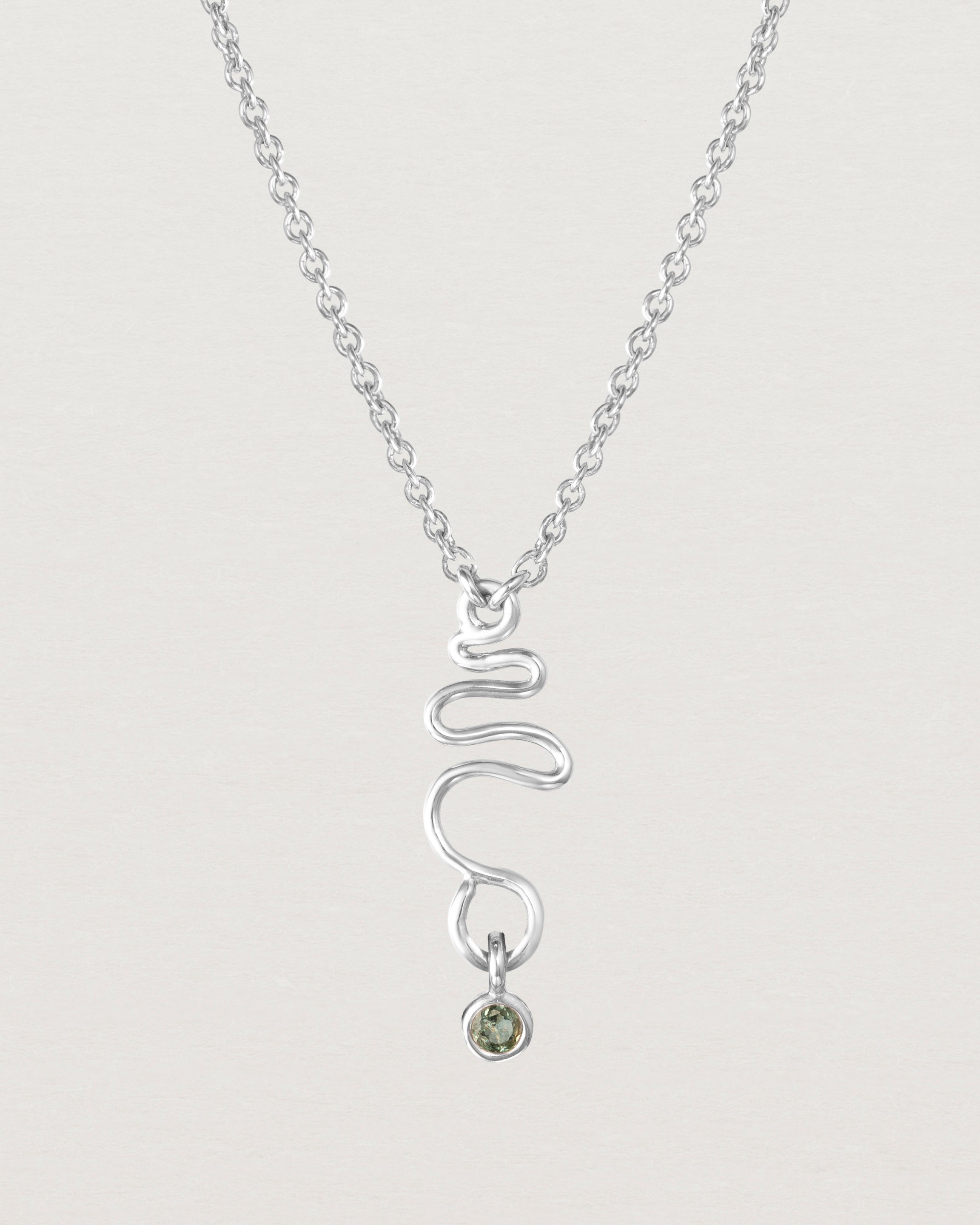 Front on deep etched image of a white gold necklace with birthstone charms.