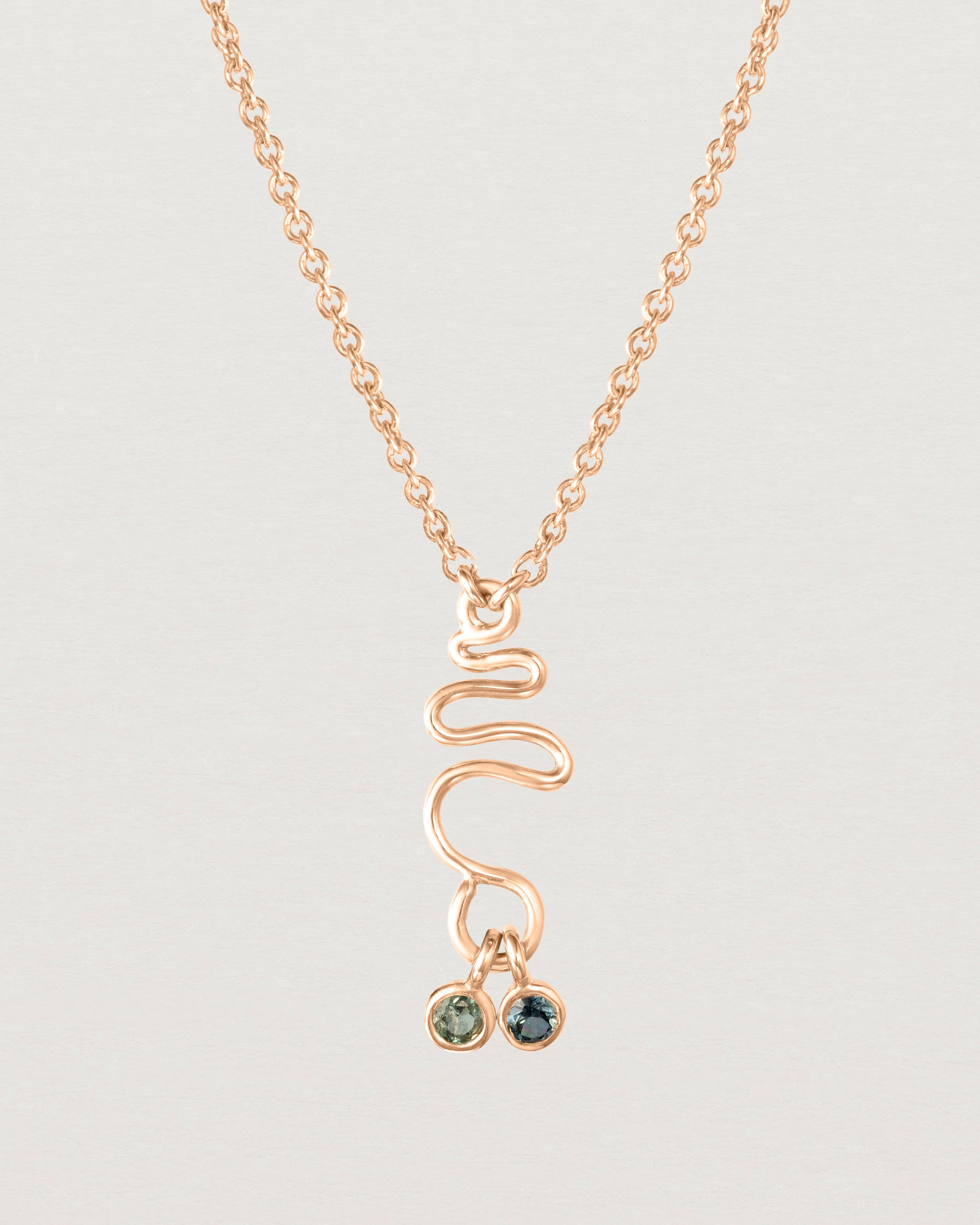 Front on deep etched image of a rose gold necklace with birthstone charms.