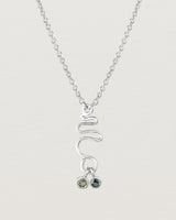 Front on deep etched image of a white gold necklace with birthstone charms.