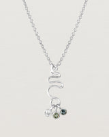 Front on deep etched image of a white gold necklace with birthstone charms.