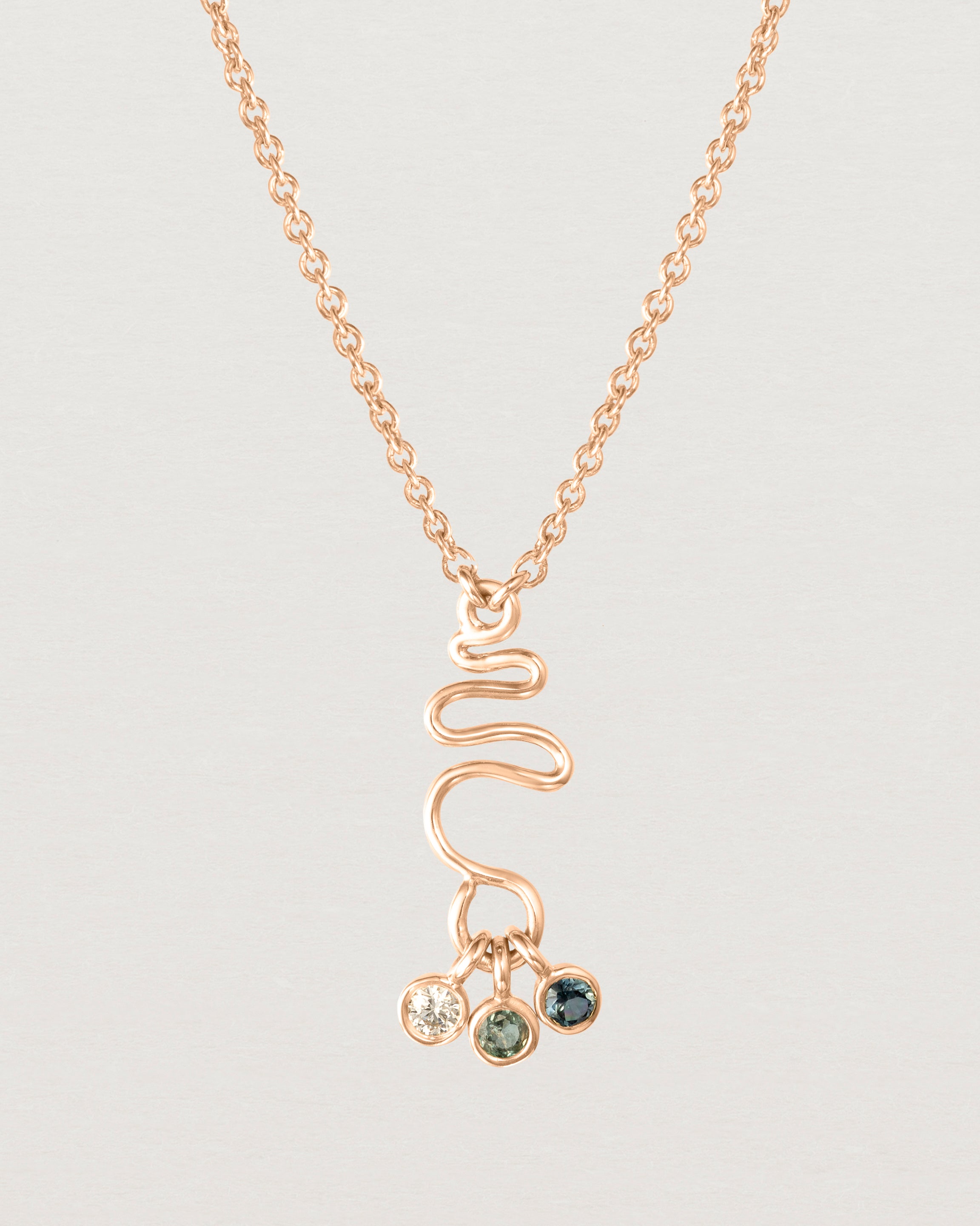 Front on deep etched image of a rose gold necklace with birthstone charms.