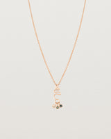 Front on deep etched image of a rose gold necklace with birthstone charms.