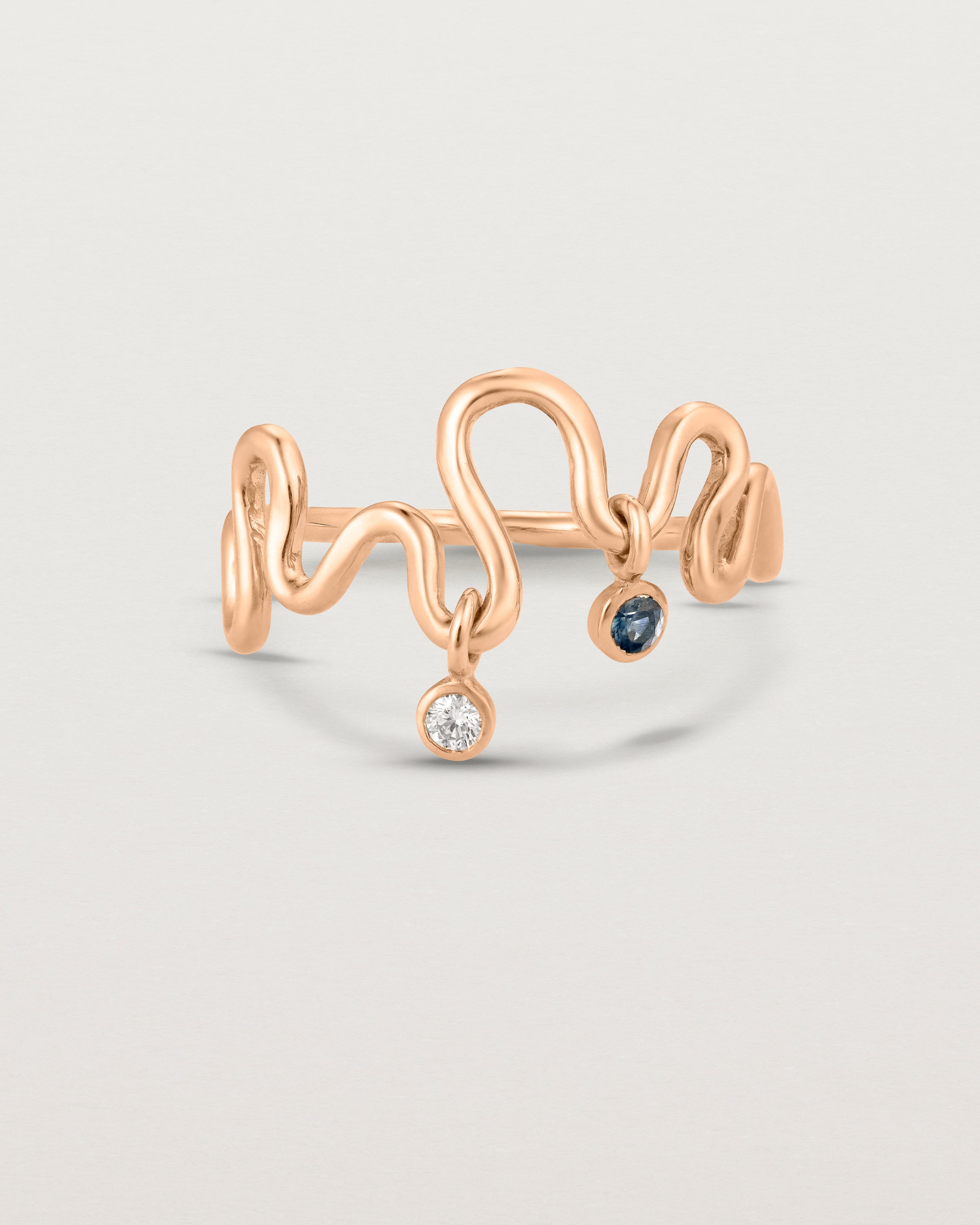 Front on deep etched image of a rose gold ring with birthstone charms.
