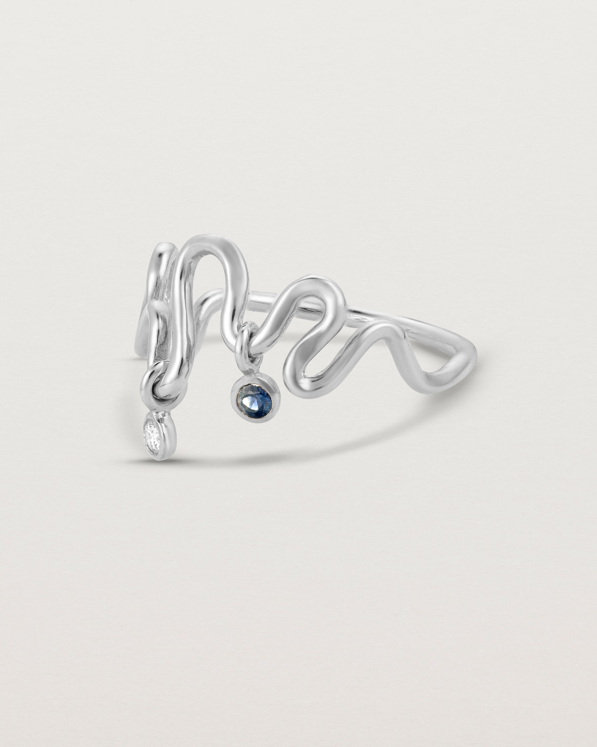 Side facing deep etched image of a white gold ring with birthstone charms.