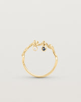 Standing deep etched image of a yellow gold ring with birthstone charms.