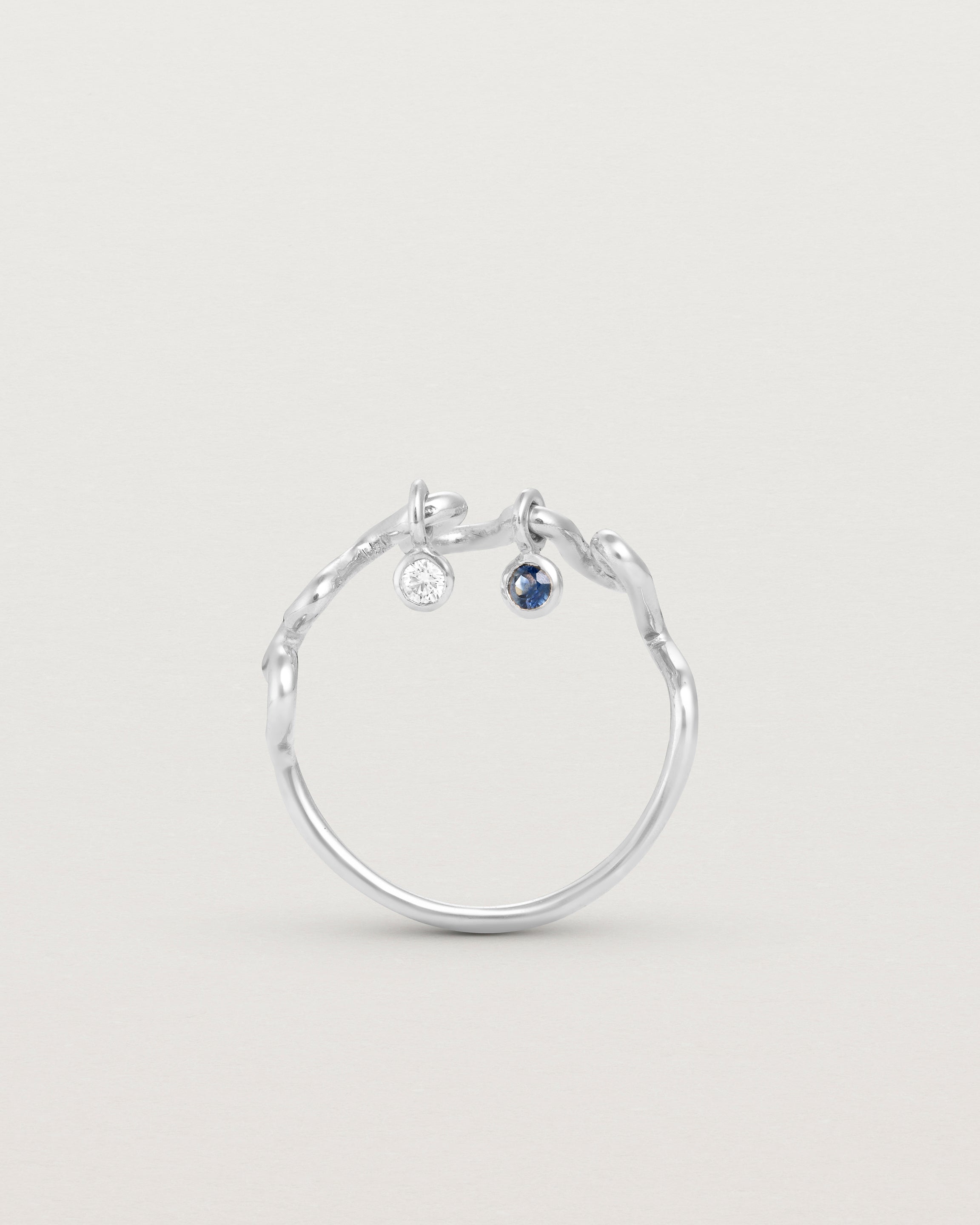 Standing deep etched image of a white gold ring with birthstone charms.