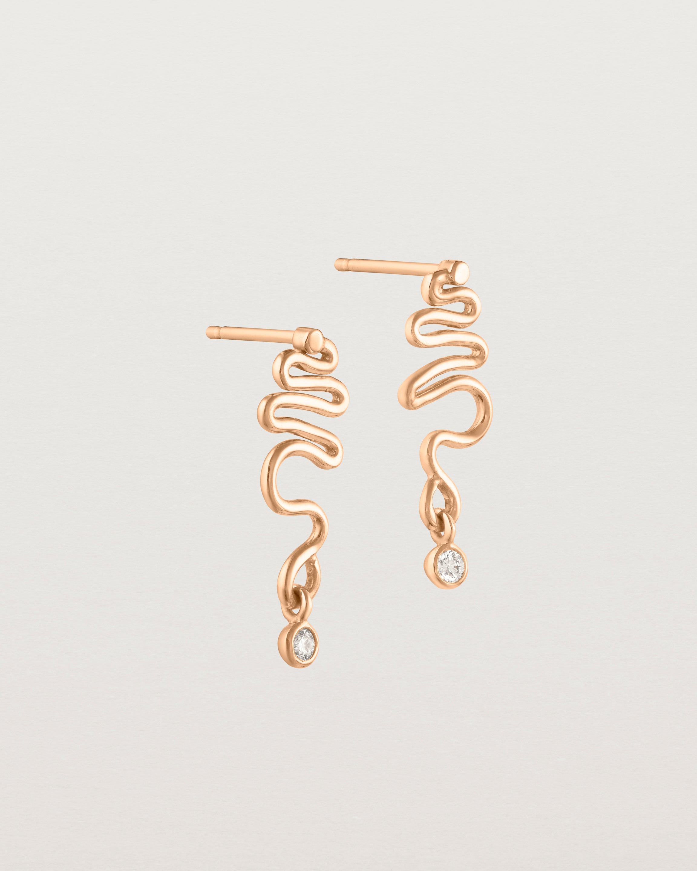 Side facing deep etched image of rose gold earrings with birthstone.