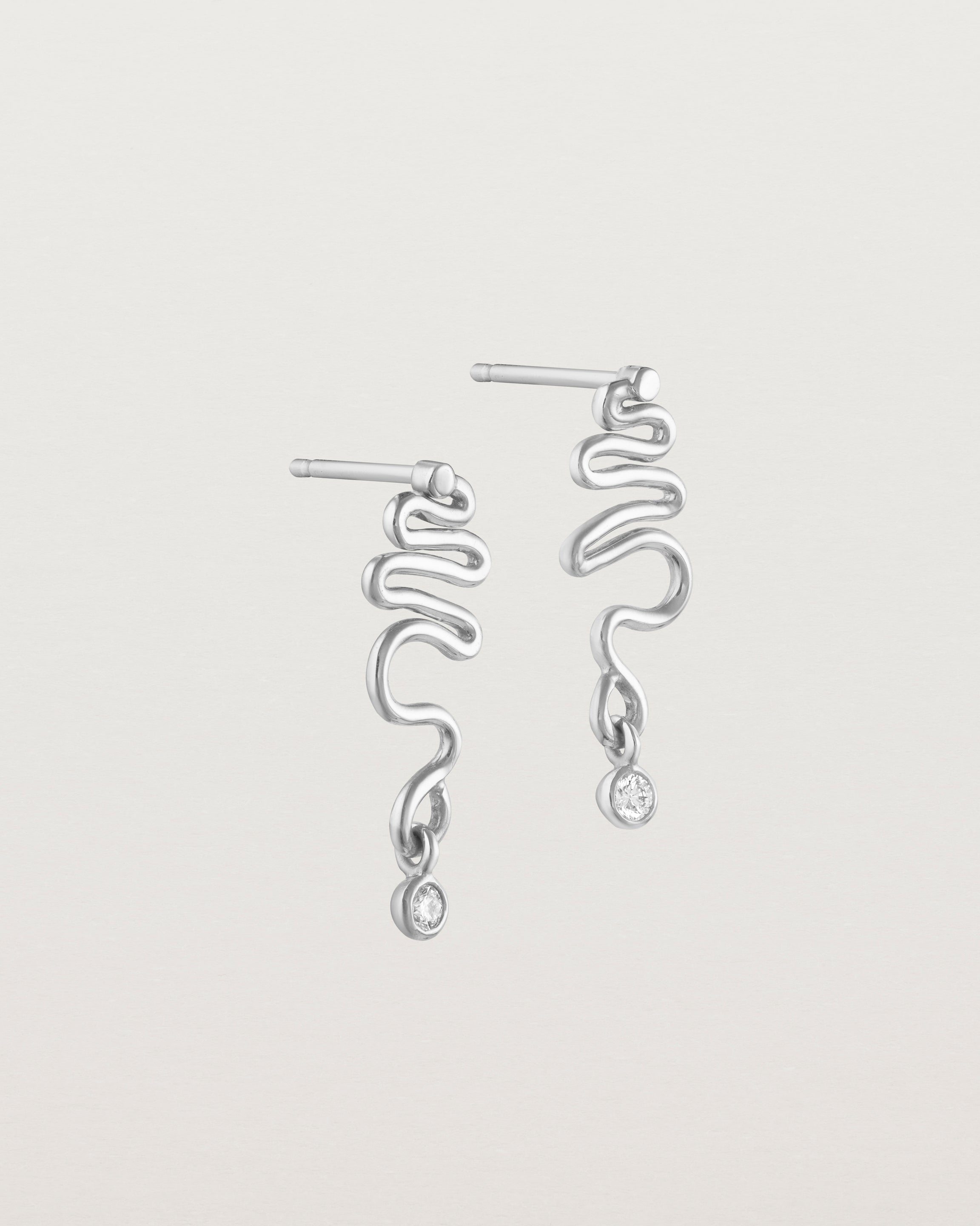 Side facing deep etched image of white gold earrings with birthstone.