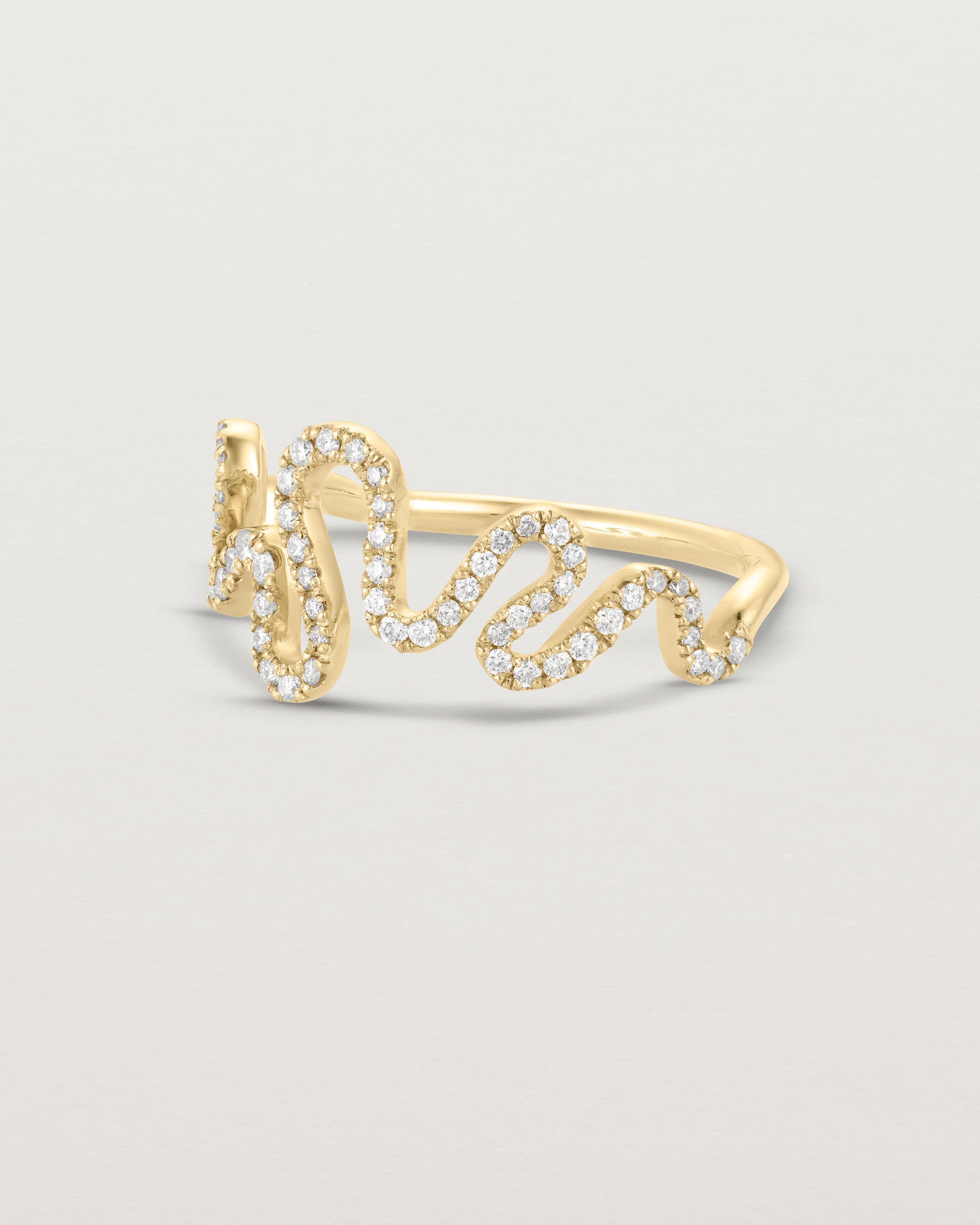 Side facing deep etched image of a yellow gold ring with a whirl of 68 diamonds.