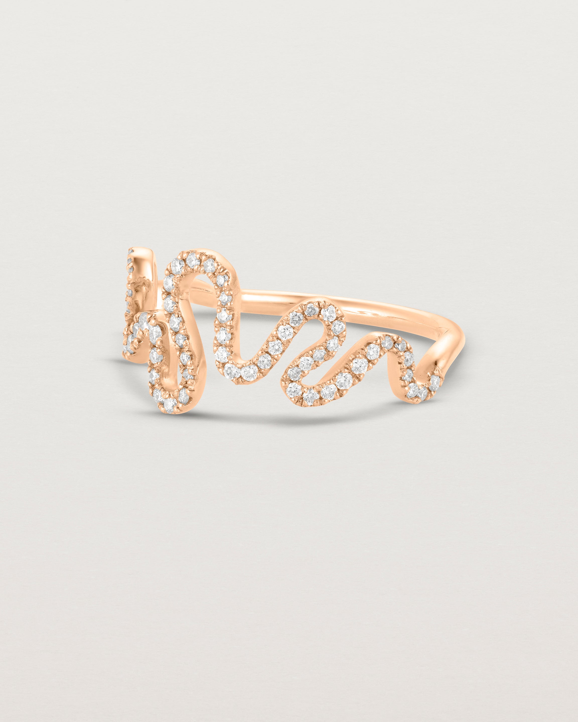 Side facing deep etched image of a rose gold ring with a whirl of 68 diamonds.