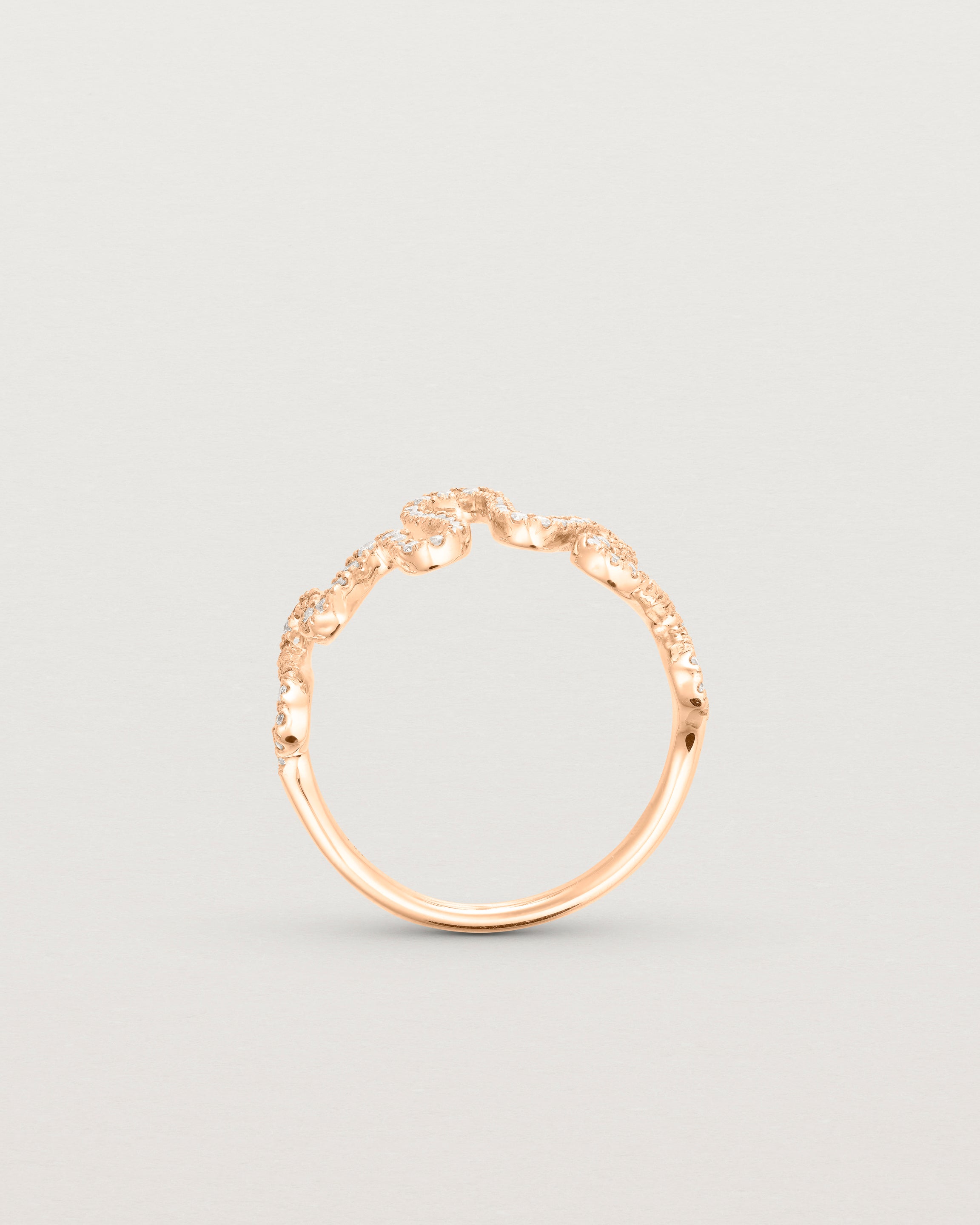 Standing deep etched image of a rose gold ring with a whirl of 68 diamonds.