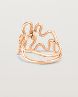 Back facing deep etched image of a rose gold ring set with charms.
