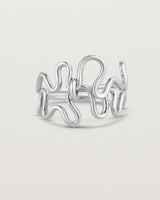 Side facing deep etched image of a white gold ring set with charms.
