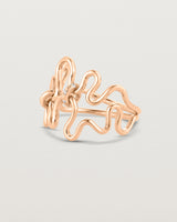 Side facing deep etched image of a rose gold ring set with charms.
