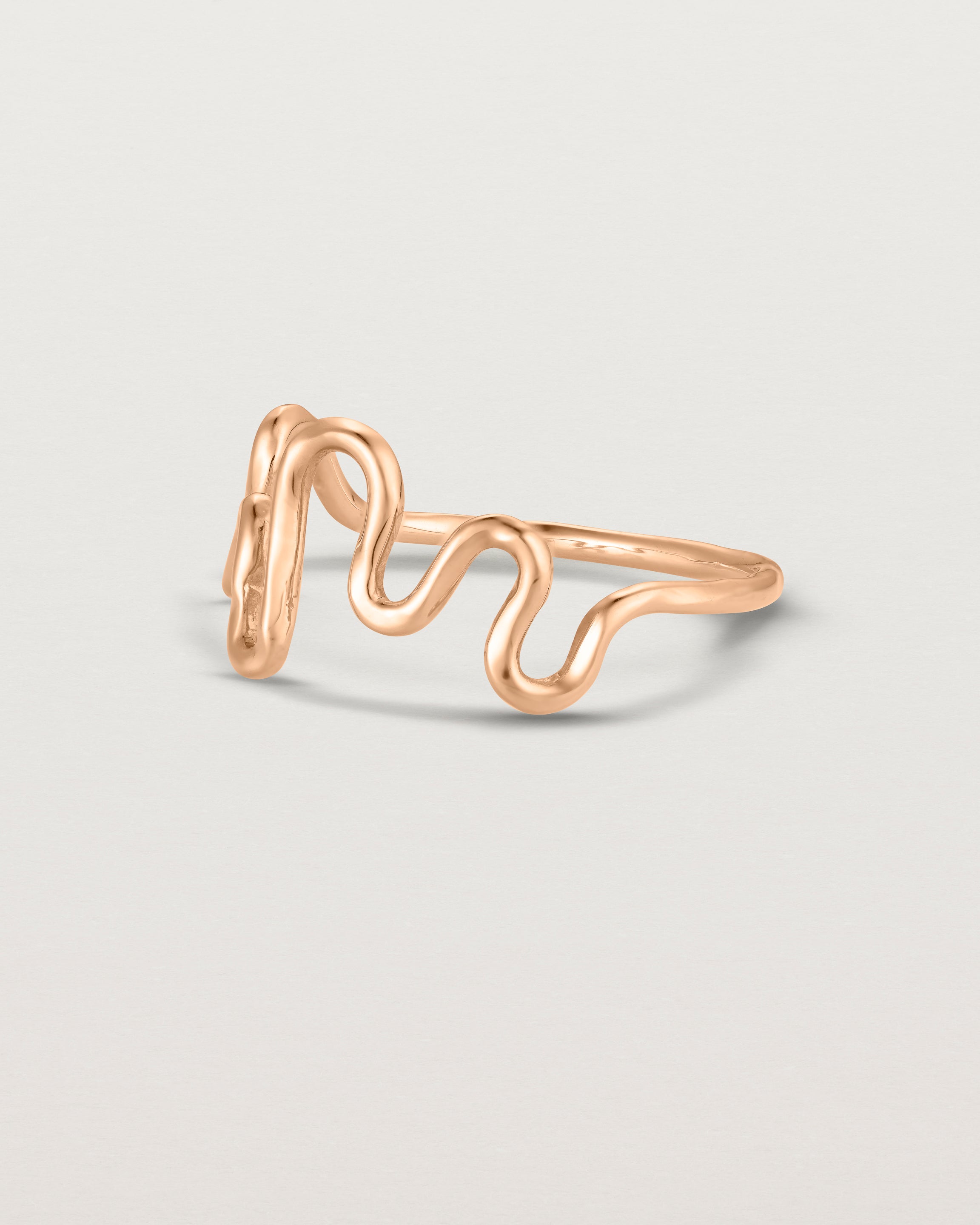 Side facing deep etched image of a rose gold ring.