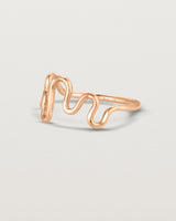 Side facing deep etched image of a rose gold ring.