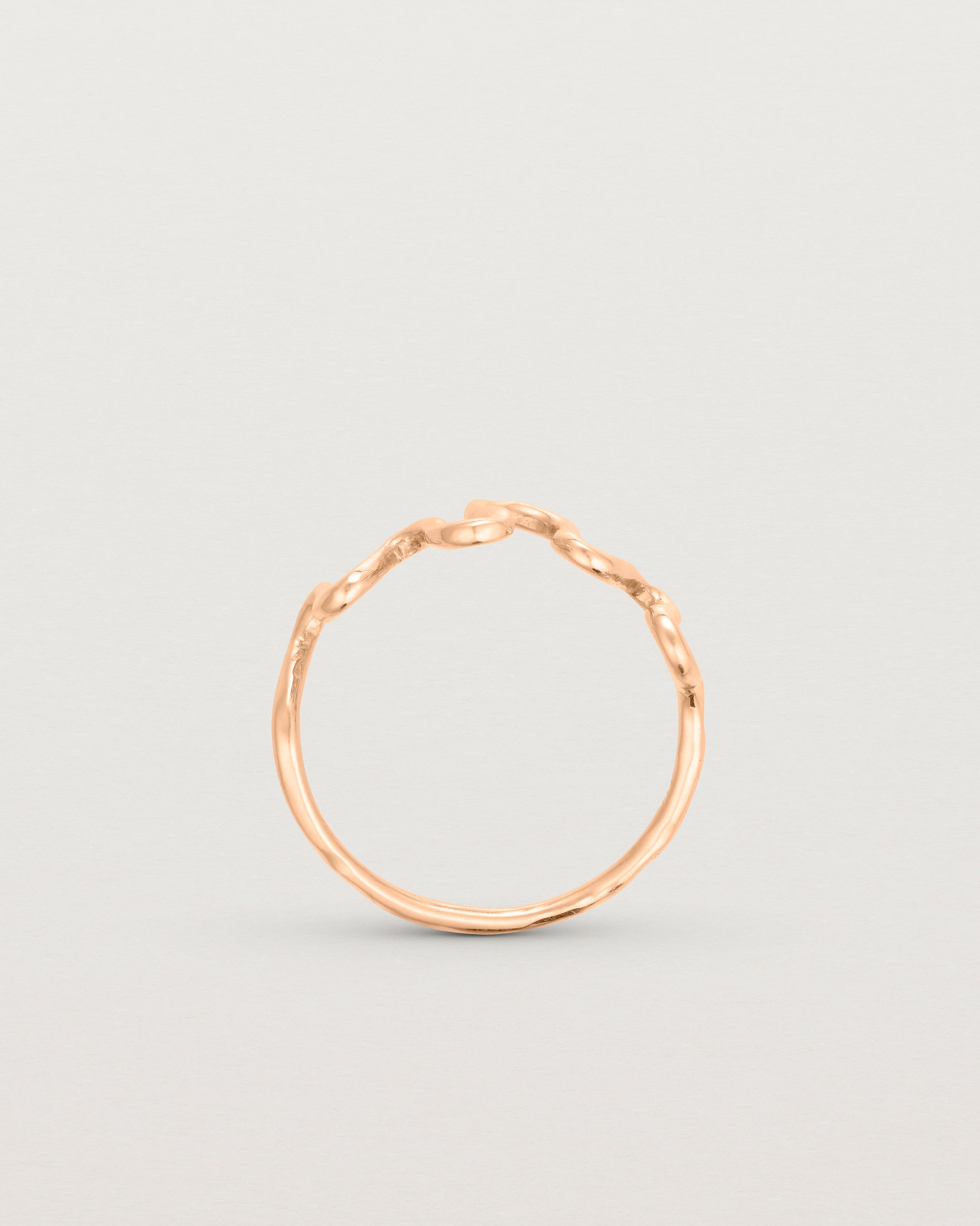 Standing deep etched image of a rose gold ring.