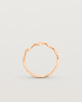 Standing deep etched image of a rose gold ring.