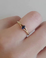 Front on deep etched video of a yellow gold engagement ring with an oval sapphire stone