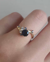 video of a white gold engagement ring with a cluster of laboratory grow diamonds and a centre sapphire stone